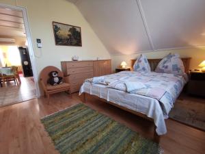 a bedroom with a bed and a dresser and a rug at Erika Apartman Klímával in Balatonkeresztúr