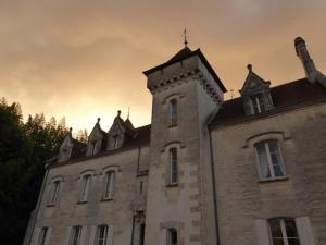 ein altes Gebäude mit einem Turm darüber in der Unterkunft Château des Salles in Saint-Fort-sur-Gironde