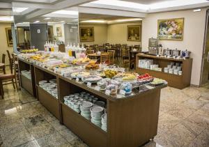 a buffet line with food on display in a restaurant at Hotel Dan Inn Express Porto Alegre - 200 metros do Complexo Hospitalar Santa Casa e UFRGS in Porto Alegre