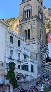 a building with a tower with a clock on it at La Suite Del Cavaliere in Amalfi