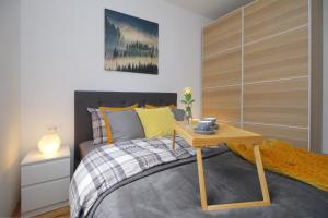 a bedroom with a bed with a table on it at Apartman Kaja in Zlatibor