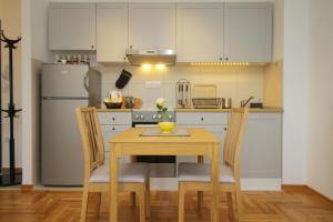 La cuisine est équipée d'une table, de chaises et d'un réfrigérateur. dans l'établissement Apartman Kaja, à Zlatibor