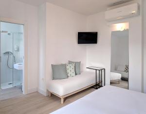 Habitación blanca con cama y baño. en Broz Hostel en Granada
