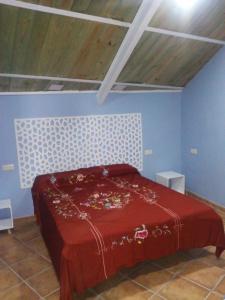 a bedroom with a red bed in a blue room at Casita para dos con piscina privada in Torres +39 photos