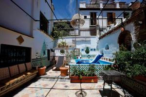 a courtyard with potted plants and a swimming pool at Oripando Hostel in Granada