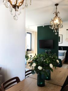 a dining room with a table with a vase of flowers at Green Apartment Gdańsk z GARAŻEM in Gdańsk