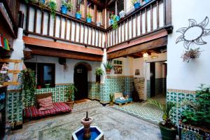 an indoor courtyard with a large building with plants at Oripando Hostel in Granada
