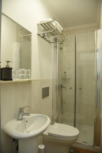a bathroom with a toilet and a sink and a shower at Flor da Primavera - Residencial e Apartamentos in Azambuja +33 photos