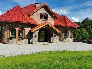 una casa de ladrillo con techo rojo en Zamoček en Matiašovce