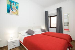 a bedroom with a bed with a red blanket at Apartments Santa Maria in Dubrovnik