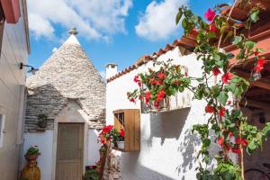 a white building with flowers in a window at Sogni d'oro in Alberobello