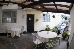 a patio with two tables and chairs and a building at The Poppy House in Bishops Castle