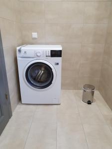 a washing machine in a room with a trash can at Donar cottage in Kuru +14 photos