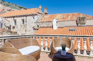 a balcony with two chairs and a table and a building at Villa Palo Alto in Dubrovnik