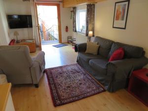 a living room with a couch and a rug at Ferienwohnung Klosterpfad in Rhodt unter Rietburg