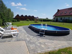 una piscina con sillas y un tobogán en un patio en Domki Morskie Opowieści en Nickelswalde