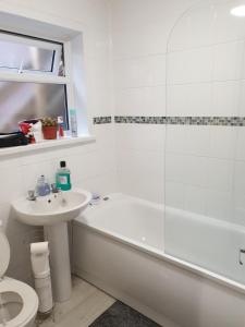 a bathroom with a tub and a sink and a toilet at Chatham Private Rooms in Chatham