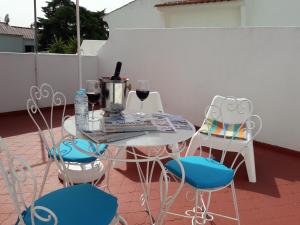 einen Tisch und Stühle mit Weingläsern auf der Terrasse in der Unterkunft Familia Brito in Porches