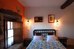 a bedroom with a bed with two pillows and a window at La Casona de Villanueva de Colombres in Villanueva