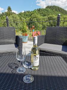 una botella de vino y dos copas de vino en una mesa en Zamoček en Matiašovce