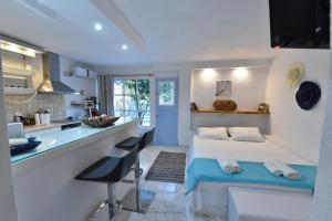 a room with a bed and a kitchen with a counter at jasmine apartments in Eretria
