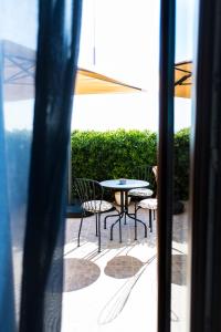 um pátio com uma mesa e cadeiras no exterior de uma janela em L'oasi di Giorgia em Cittadella del Capo