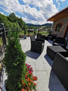 un patio con sillas y un árbol de Navidad y flores en Zamoček en Matiašovce