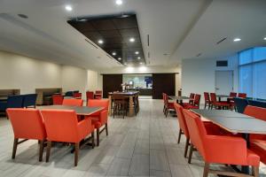 乔治城乔治敦快捷度假酒店的一间有桌椅的餐厅和一间自助餐厅