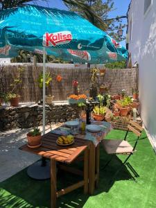 una mesa de picnic con una sombrilla y frutas. en Casa Palmera y Casa Dátil, en Haría