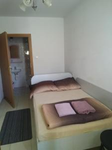 ウォミアンキにあるHostel Malvaのベッド2台とバスルームが備わる小さな客室です。