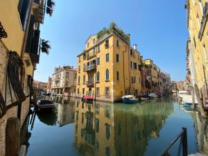 a canal with buildings and boats in the water at Suite House new apartments canal view Venice island in Venice