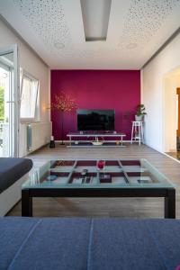 uma sala de estar com uma parede vermelha e uma mesa de centro em Apartman Ana em Novi Vinodolski