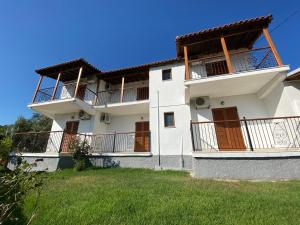 a large white building with balconies and a yard at Valmas village in Skiathos Town