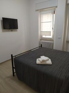 ein Schlafzimmer mit einem Bett mit zwei weißen Handtüchern darauf in der Unterkunft Siclanda Home in Sanremo
