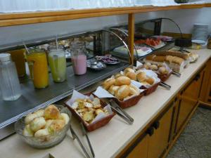 uma linha de buffet com muitos tipos diferentes de alimentos em HOTEL VARGINHA em Varginha