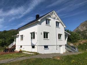 une maison blanche avec une table de pique-nique devant elle dans l'établissement Vestfjorden Panorama Lofoten, à Valberg
