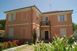 duży pomarańczowy dom z kwiatami przed nim w obiekcie Il Melo Antico - appartamenti in villa d'epoca nel cuore del Monferrato w mieście Acqui Terme