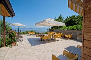a patio with tables and chairs and umbrellas at Guesthouse Opara in Piran