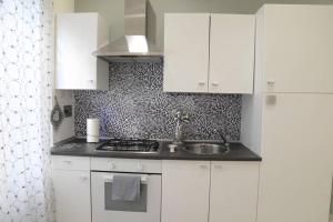 eine Küche mit weißen Schränken und einem Waschbecken in der Unterkunft A casa di Rosa in Rom