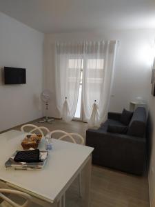 ein Wohnzimmer mit einem Sofa und einem Tisch in der Unterkunft Siclanda Home in Sanremo