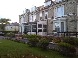 a large brick house with flowers in front of it at Clifton Hotel & Bar Newcastle in Elswick