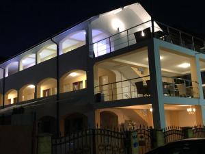 a large white building with a balcony at night at Villa Raul in Costinesti