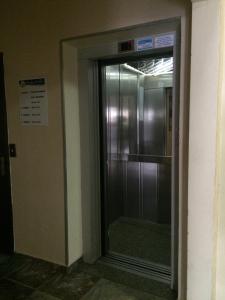 a glass door to a elevator in a building at Perea Hotel in São Carlos