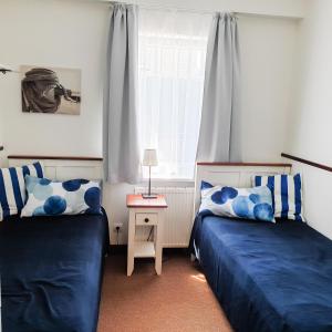sypialnia z 2 łóżkami i oknem w obiekcie Villa Baltic Chałupy Apartament 4 w Chałupach