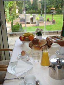 a table with a breakfast of eggs bread and fruit at Hotel Handelia in Handel