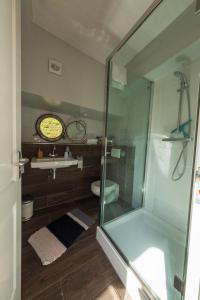 een badkamer met een glazen douche en een wastafel bij De Coaster in Rotterdam