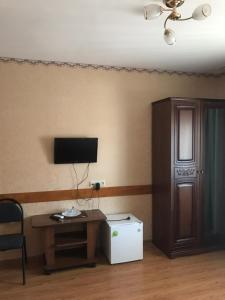 a room with a desk and a tv on a wall at Guest house Fortuna in Adler