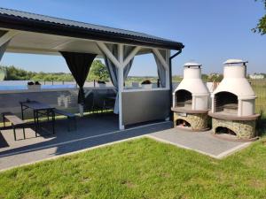 a patio with two heaters and a table and chairs at Aurora Ustka-Przewłoka in Ustka