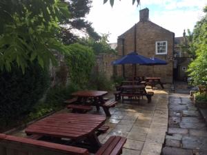 a group of picnic tables and an umbrella on a patio at Coach and Horses in Barnard Castle +21 photos