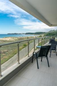 a balcony with chairs and a view of the beach at Aparthotel Primorsko in Primorsko